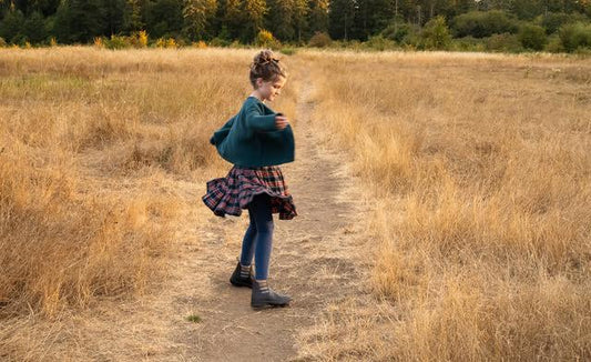 Girl in skirt & sweater twirling 