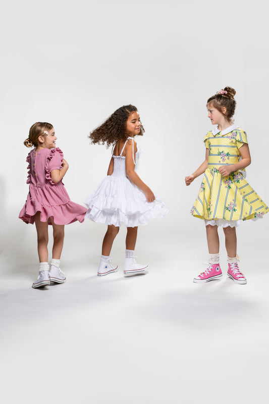 3 girls twirling in handmade sustainable kids dresses, fashionable girls dresses