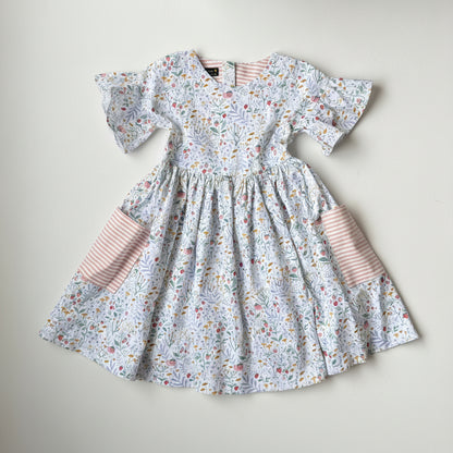 Floral dress with ruffled sleeves and pink striped accents on a light background