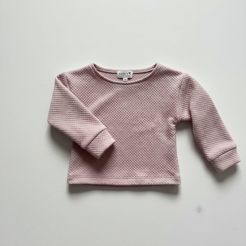 Pink textured sweater on a light gray background