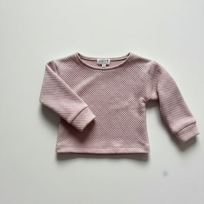 Pink textured sweater on a light gray background