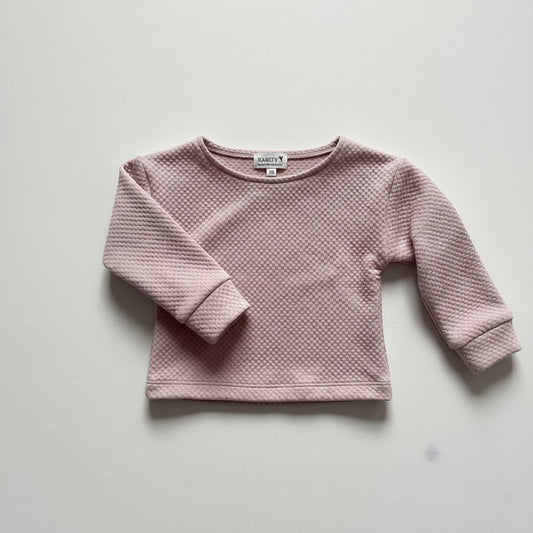 Pink textured sweater on a light gray background